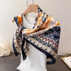 Vintage bohemian paisley printed silk scarf displayed on a wooden hanger with luxury decor