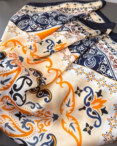 Detail of vintage paisley silk scarf featuring premium navy blue and orange floral patterns