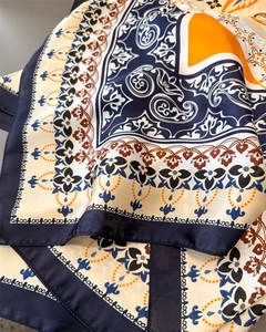 Detailed macro view of retro paisley silk scarf texture with rich blue and orange patterns