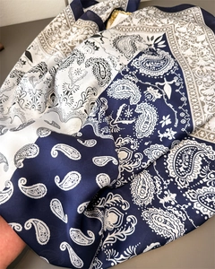 Detail of paisley pattern and satin texture on navy and taupe patchwork silk-like scarf