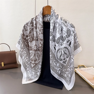 Close-up of paisley print satin scarf draped on a hanger with elegant silk texture