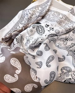 Close-up of paisley print satin scarf with soft drapes and elegant silk-like texture