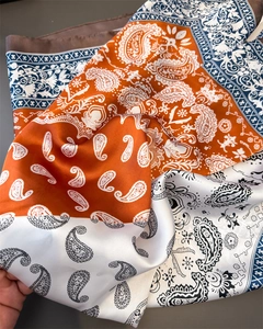 Detail of silk-satin scarf showing paisley patterns and smooth glossy texture