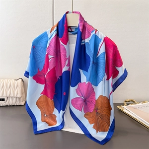 Detailansicht des farbenfrohen Satin-Seidenschals mit Ginkgo-Print und elegantem blauem Rand