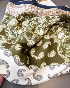 Detail of silk satin scarf showing paisley print and olive green, white and navy colors
