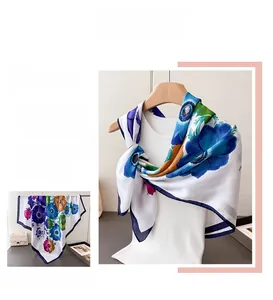 Vue détaillée d'un grand foulard en satin avec motifs floraux bleus et orange vifs