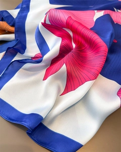 Detail eines Satin-Schals mit Ginkgo-Print, glatter Textur und lebendigen Blumenmustern