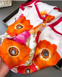 Détail d'un foulard en soie satinée à imprimé pavot avec des bords roulés rouges vifs