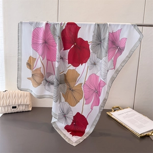 Eleganter Satin-Viereckschal mit buntem Ginkgo-Druck hängend in häuslicher Umgebung