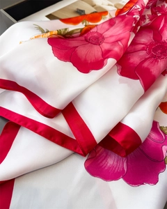 Détail d'un foulard en satin à fleurs avec bords rouges montrant la texture soyeuse