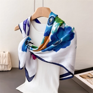 Élégant foulard en satin de soie à imprimé floral bleu porté sur un gilet blanc côtelé