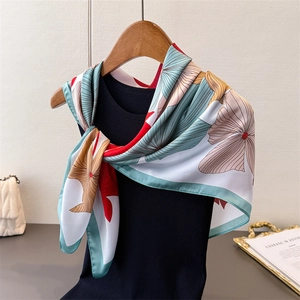 Detailansicht eines farbenfrohen Ginkgo-Satin-Schals, der elegant an einer Puppe hängt