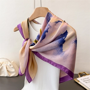 Elegant silk-like scarf with purple abstract print and deep violet borders on a model
