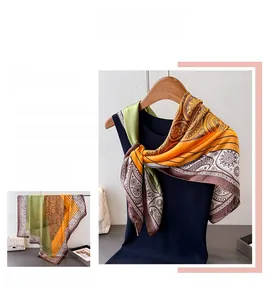 Detail of army green and yellow paisley satin scarf showing fabric texture and patterns
