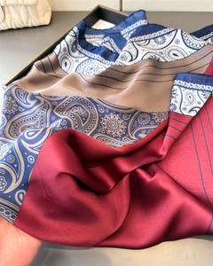 Close-up of red and blue paisley print satin scarf showing silky texture and drape
