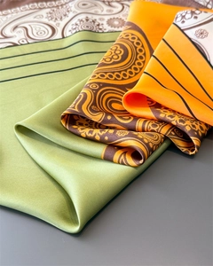Close-up of silky satin scarf featuring retro paisley pattern and vibrant color blocks