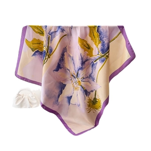 Elegant silk-like scarf with purple floral print and pearl handle bag on white backdrop