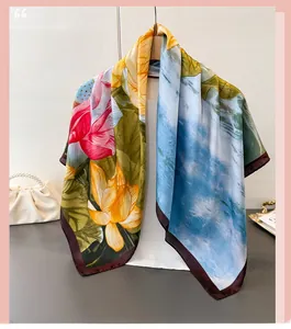 Detailed view of ink lotus silk scarf with bright floral patterns and contrast borders