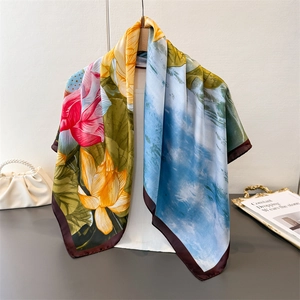 Ink painting lotus silk square scarf with vibrant floral print displayed on a hanger