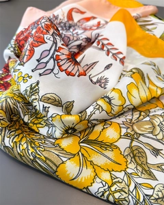 Macro-opname van lavendel bloemenprint op zijden sjaal met gele rand en zachte textuur