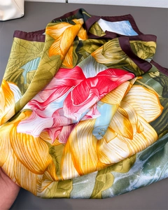 Detailed view of ink lotus silk scarf fabric with glossy texture and brown hem edge