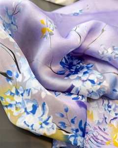 Detailopname van lavendelkleurige zijden sjaal met elegante bloemenprints