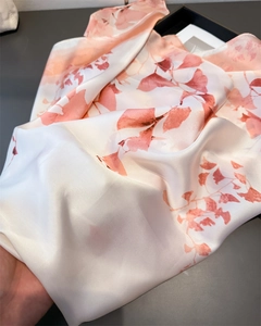 Detail of silk-like scarf featuring soft ink lotus print and smooth satin texture