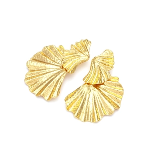 Détail des boucles d'oreilles feuilles de ginkgo dorées avec texture métal martelé