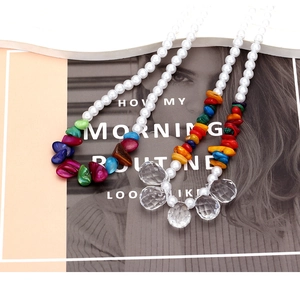 Bohemian multilayered pearl necklace with colorful gravel and crystal pendants on magazine