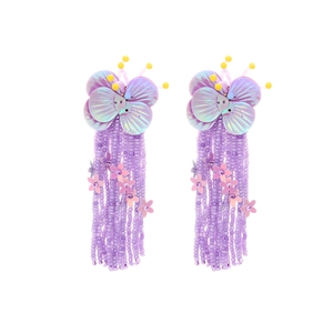 Detail of purple beaded tassel earrings with iridescent butterfly sequins and pink flowers