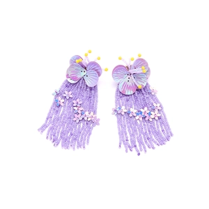 Close-up of handmade purple beaded fringe earrings with sequins and flower details