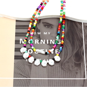 Bohemian multi-colored bead and baroque pearl layered necklace on a fashion magazine background