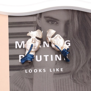 Artistic abstract human face earrings with matte metallic texture and blue silent hand