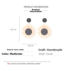 Detail view of woven raffia flower earrings with dimensions and houndstooth fabric button