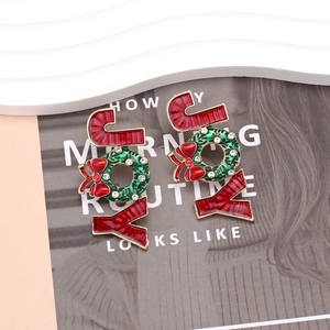 Weihnachts-JOY-Ohrringe mit Emaille-Schleife und Strass auf einem dekorativen Ständer