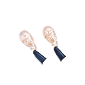 Artistic gold face mask earrings with sleek black drops in a minimalist pop art style