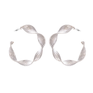 Silver twisted metal hoop earrings with artistic textured finish in a bold retro design
