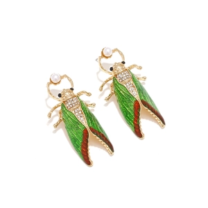 Detailed view of enamel cicada earrings with green wings and sparkling crystals