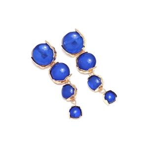 Detailaufnahme blauer Harz-Cabochons in goldenen geometrischen Hängeohrringen