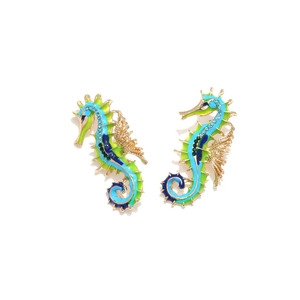 Close-up of colorful enamel seahorse earrings with sparkling blue and green rhinestones