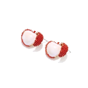 Detalle de los pendientes de lichi con textura roja y núcleo blanco de estilo creativo