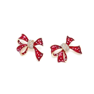 Boucles d'oreilles nœud rouge à pois blancs et cristaux brillants sur fond blanc
