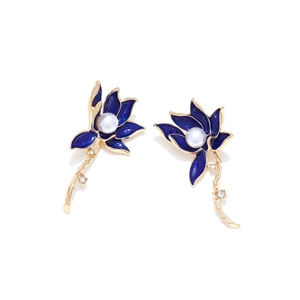 Macro detail of blue enamel flower earrings with white pearl center and gold alloy petals