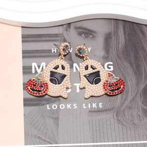 Ghost and pumpkin earrings with pearls and rhinestones on a fashion magazine