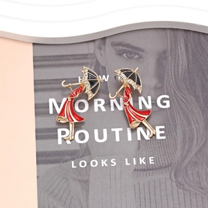 Fashionable lady with umbrella earrings in gold alloy with red and black enamel