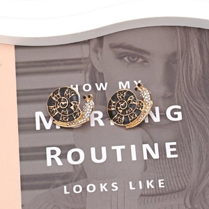 Artistic gold snail stud earrings with black enamel shell and sparkling crystals