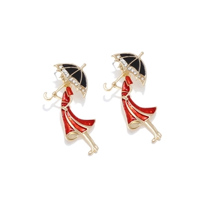 Detail of creative umbrella lady earrings with red enamel dress and sparkling rhinestones