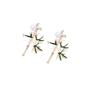 Détail de boucles d'oreilles bambou avec feuilles émaillées, perles et cristaux