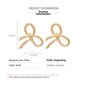 Detail view of gold bow knot earrings with twisted texture and size specifications