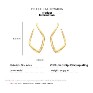 Detailed view of wavy geometric gold-finish alloy earrings with 6.8cm height dimensions